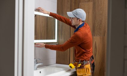 A Man Installing Bathroom Mirror Cabinet